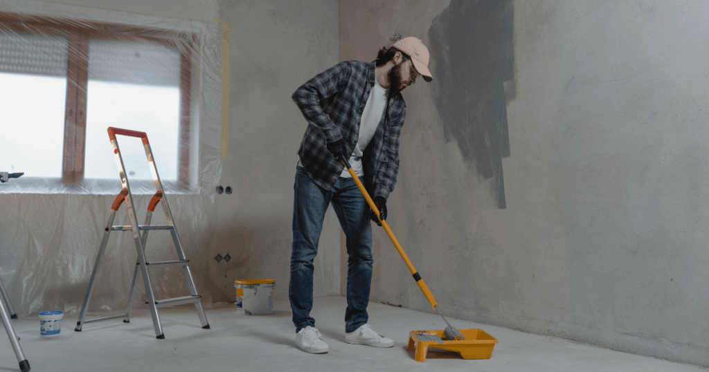 Homem aplicando tinta para parede
