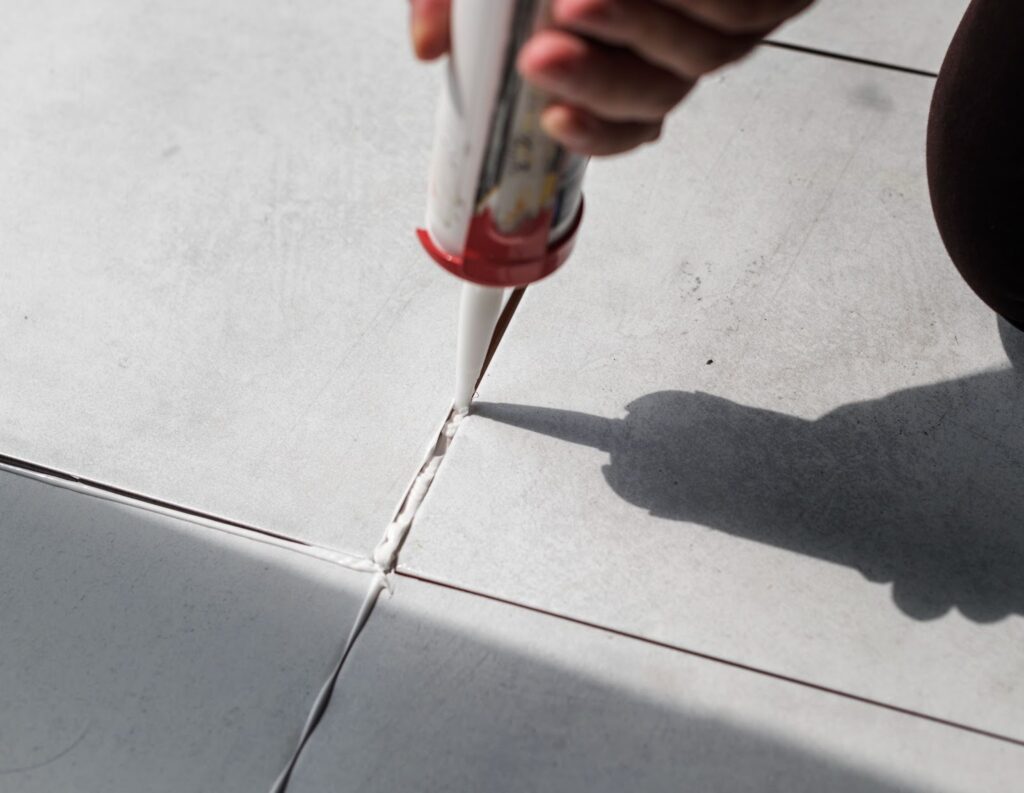 profissional aplicando selante para vedação nas juntas de revestimento
