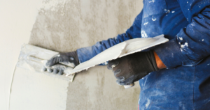 profissional aplicando argamassa para reboco em parede interna